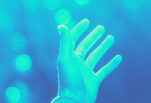 Glowing blue hand symbolising how people feel energy during energy healing.